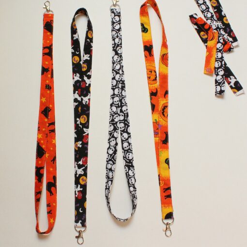 Lanyards in orange with bats, pumpkins, Back cats, one in black with white skulls